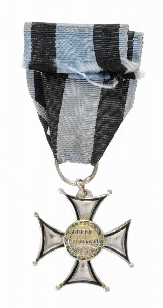 Krzyż równoramienny o rozszerzających się ramionach. Końce ramion lekko wklęsłe, rogi zakończone kulkami ( jednej kulki brak). Na awersie wypukłych ramion obwódka i napis: VIR-TUTI MILI-TARI z czarnej emalii, na tarczy orzeł w koronie wypełniony białą emalią oraz otok z wieńcem laurowym pokrytym zieloną emalią. Na tarczy rewersu napis HONOR I OJCZYZNA poniżej data 1792, oraz wieniec laurowy. Wstążka orderu rypsowa niebieska z dwoma czarnymi pasami szerokości 9 mm.