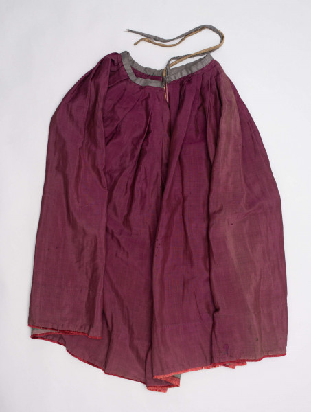 E/190/MRK/ML - Spódnica ze szczoteczką koloru biskupiego. Szyta ręcznie czarnymi nićmi. Spód obszyty szczoteczką. Obwód w pasie 67 cm. Obwód u dołu 322 cm. 