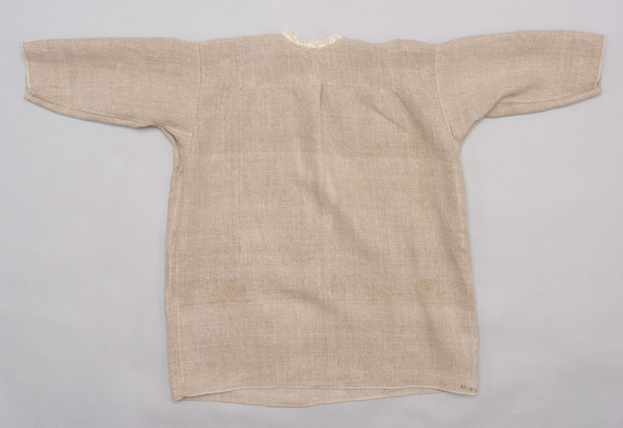 E/529/MRK/ML - Koszula damska. Uszyta z lnianego płótna z długimi rękawami, pod szyją dziurkowa pliska w kolorze białym. Na linii ramienia symetryczne zaszewki, pod szyjką pęknięcie zapinane na guzik.