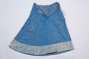 E/189/MRK/ML - Spódnica ze szczoteczką koloru niebieskiego. Obwód w pasie 72 cm. Obwód spódnicy u dołu 223 cm, od spodu obszyta niebieską szczoteczką. Z przodu wiązana na 2 sznurki.
