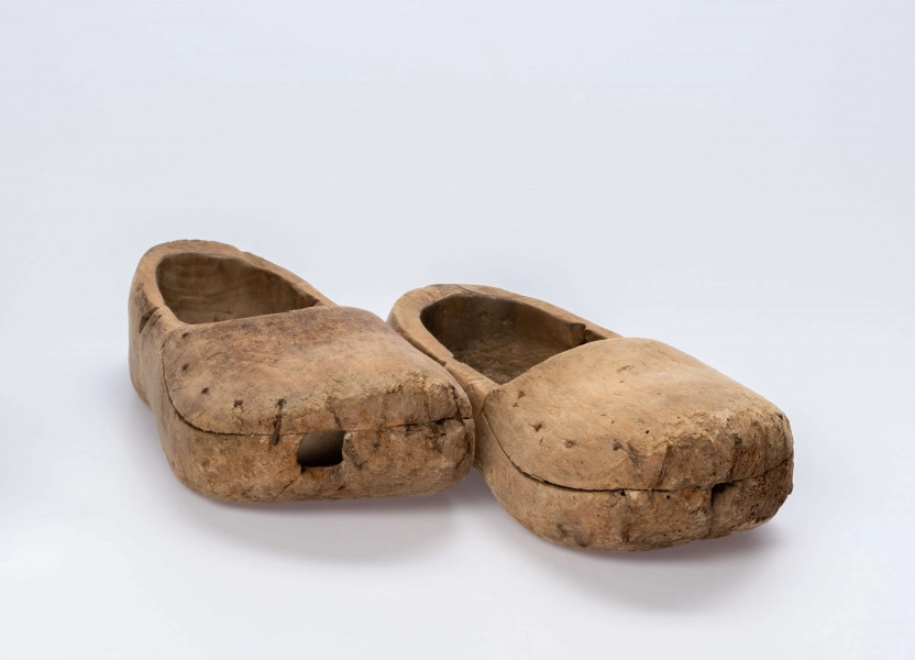 E/13/MRK/ML - Drewniaki dłubane, para. Długość 31 cm. Zrobione z dwóch kawałków drewna zbitych gwoździami. Z boku otwory do wiązania.