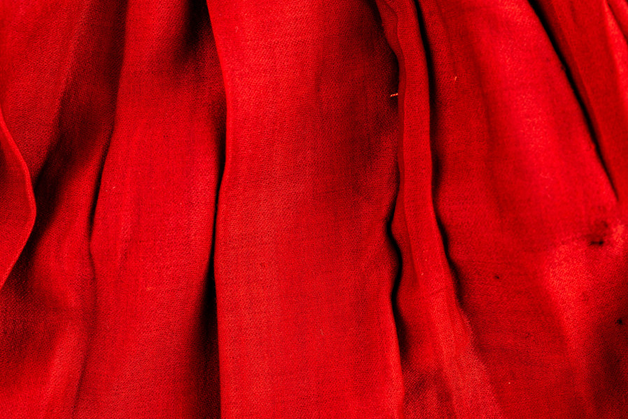 E/516/MRK/ML - Spódnica krakowska. Wykonana z wełenki, kolor czerwony. W dolnej czesci spódnica ozdobiona różnokolorowymi tasiemkami, sztuk 7. Przy oszewce lekko marszczona.