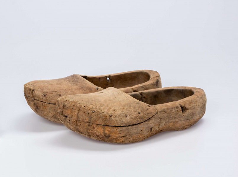 E/13/MRK/ML - Drewniaki dłubane, para. Długość 31 cm. Zrobione z dwóch kawałków drewna zbitych gwoździami. Z boku otwory do wiązania.