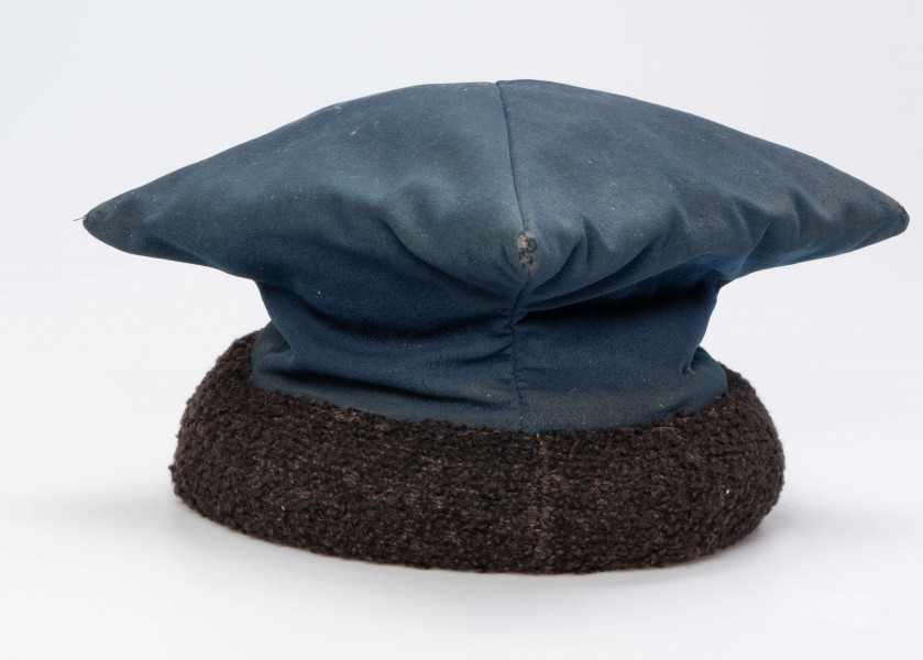 E/192/MRK/ML - Czapka rogatywka. Koloru niebieskiego z czarnym otokiem. Długość po przekątnej 30 cm. Szerokośc otoku 6,5 cm.