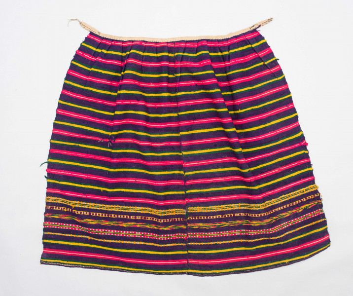 E/125/MRK/ML - Zapaska wełniana w różnokolorowe pasy, ułożone poziomo. Dł. zapaski 77 cm, szer. 98 cm, zszyta w środku. Kolory: fioletowy, niebieski, czerwony, biały, zielony, żółty, brązowy. Od góry 14 zakładek na nich naszyty lniany pasek szer. 1 cm, dł. 65 cm.