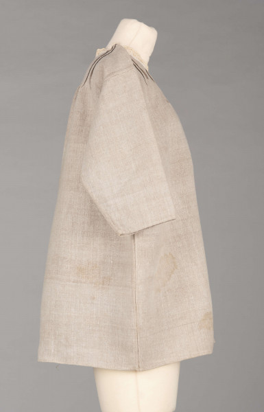 E/529/MRK/ML - Koszula damska. Uszyta z lnianego płótna z długimi rękawami, pod szyją dziurkowa pliska w kolorze białym. Na linii ramienia symetryczne zaszewki, pod szyjką pęknięcie zapinane na guzik.