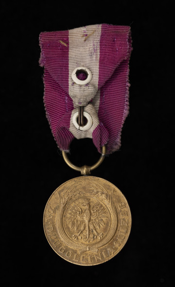 Medal Za Długoletnią Służbę III stopnia - awers; wypukły wizerunek orła państwowego, wg wzoru z 1927, w otoku stylizowanego ornamentu: wieńca składającego się z przewiązanych u dołu dwóch wiązek kłosów zboża. W dolnej części medalu równolegle do podniesionej krawędzi tłoczony napis: ZA DŁUGOLETNIĄ SŁUŻBĘ, przy czym słowa przedzielone rombami. Zawieszenie z przylutowanego, beczułkowatego uszka i przewleczonego kółeczka. Wstążka z mory jedwabnej, amarantowa z białym pionowym pasem z oryginalnym zapięciem na haftkę.