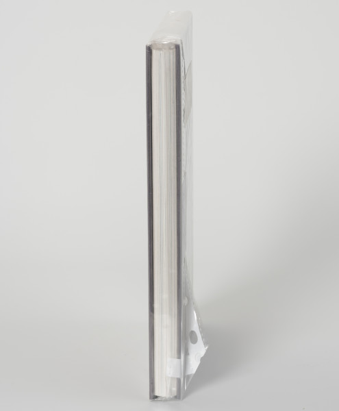 Ryszard Górecki. Tajne konstrukcje lotnicze PRL - ujęcie z boku; Obłożony w foliową koszulkę obiekt-książka. Widok na wewnetrzną stronę zamknietej ksiązki.