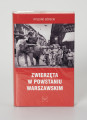 Ryszard Górecki. Zwierzęta w Powstaniu Warszawskim - ujęcie z przodu; Obłożony w foliową koszulkę obiekt-książka. Na frontowej stronie czerwonej okładki od góry: białymi literami nazwisko autora (RYSZARD GÓRECKI), poniżej fotomontaż z przedstawieniem czarno-białej sceny z Powstania Warszawskiego (fragment ulicy przedstawionej w perspektywicznym skrócie, obie pierzeje ciasno zabudowane kilkupiętrowymi kamienicami, na pierwszym planie po prawej grupa uzbrojonych powstańców, po lewej słoń z koszem na grzbiecie, w koszu powstaniec z pistoletem i małpa z granatem, pod zdjęciem białymi literami: tytuł publikacji (ZWIERZĘTA W POWSTANIU WARSZAWSKIM) oraz logo wydawnictwa Niewidzialny Znak.