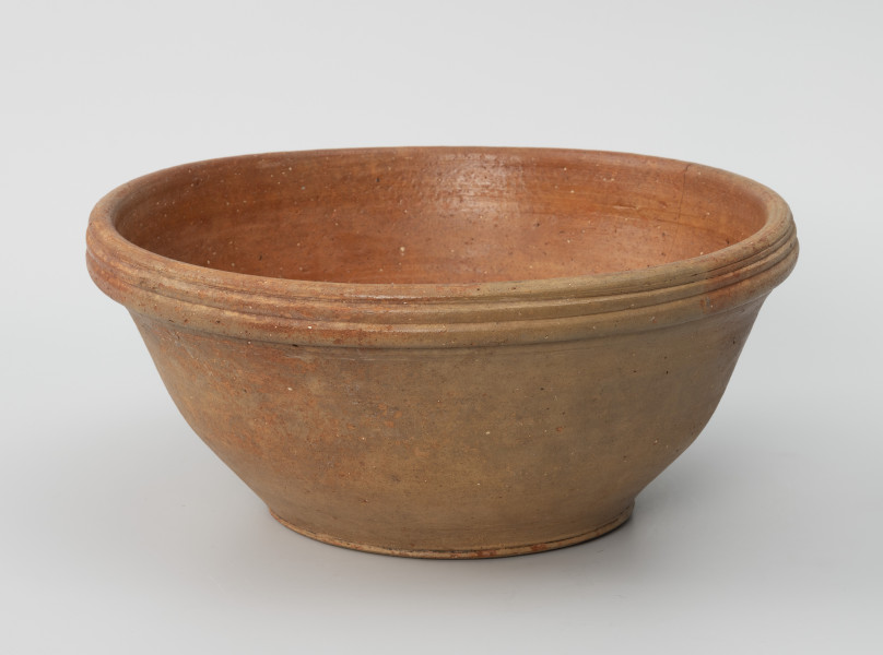 makutra - Ujęcie z przodu; Naczynie w formie misy o szerokim wylewie zakończonym kołnierzem z trzema dookolnymi paskami. Dno słabo wyodrębnione. Od wewnątrz pokryta biegnącymi wokół ścianek rowkami, dzięki którym proces ucierania przebiegał łatwiej i szybciej. Prawdopodobnie dno pierwotnie także zaopatrzone było w rowki, obecnie silnie starte. Zewnętrzne ścianki naczynia z niewielkimi wypukłościami odpowiadającymi rowkom we wnętrzu.