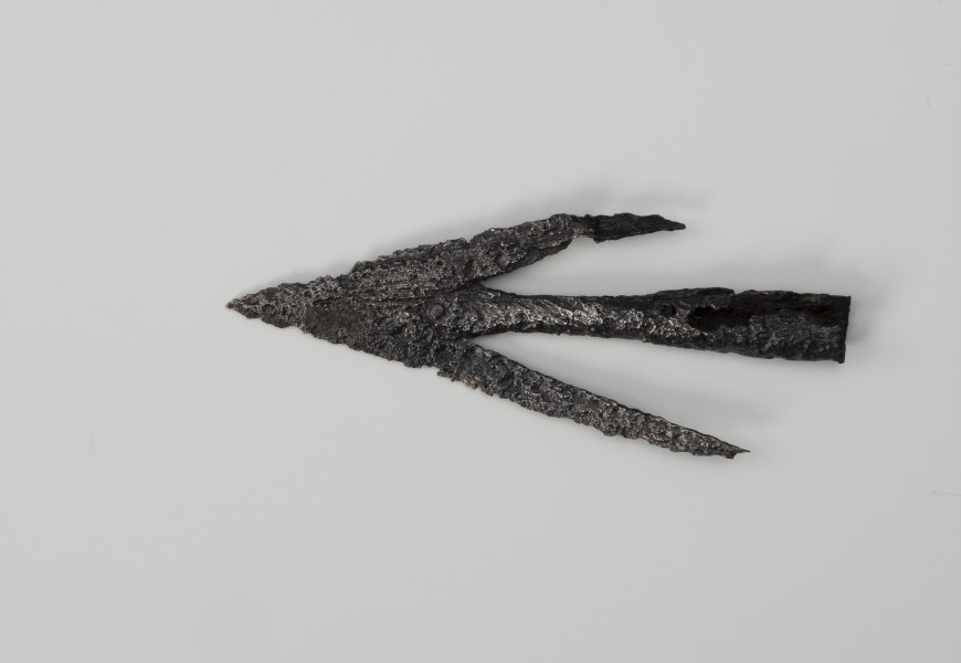 Grot strzały łuku - ujęcie z góry; Żelazny grot strzały łuku charakteryzuje się długimi zadziorami liścia i stożkowatą tulejką do osadzenia na drzewcu.