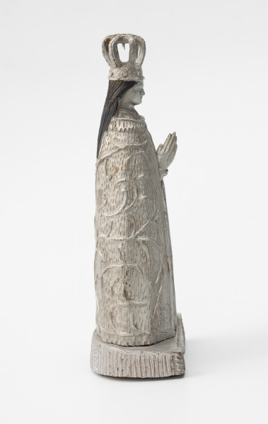 Matka Boska Skępska - ujęcie z boku; Rzeźba przedstawiająca figurę Matki Boskiej znajdującej się w kościele Zwiastowania Najświętszej Maryi Panny, w klasztorze ojców Bernardynów w miejscowości Skępe (województwo kujawsko-pomorskie). Postać kobieca wykonana w jednym kawałku drewna stoi na postumencie o kształcie półkola. Oba elementy połączone są ze sobą w sposób niewidoczny, prawdopodobnie za pomocą bolca lub kleju. Rzeźba pełna, wolnostojąca, statyczna, pomalowana w całości srebrną farbą – poza czarnymi włosami. Na głowie postaci duża ażurowa korona, włosy luźno spływają na plecy. Dłonie o wydłużonych palcach modlitewnie złożone na piersiach są jedyną częścią ciała widoczną poza okrywającą całą postać szatą zdobioną motywem roślinnym.