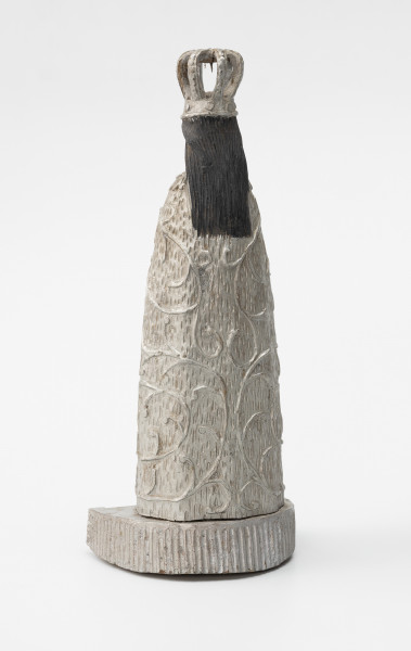 Matka Boska Skępska - ujęcie z tyłu ze skosu; Rzeźba przedstawiająca figurę. Postać kobieca wykonana w jednym kawałku drewna stoi na postumencie o kształcie półkola. Oba elementy połączone są ze sobą w sposób niewidoczny, prawdopodobnie za pomocą bolca lub kleju. Rzeźba pełna, wolnostojąca, statyczna, pomalowana w całości srebrną farbą – poza czarnymi włosami. Na głowie postaci duża ażurowa korona, włosy luźno spływają na plecy. Całą postać okrywa szata zdobiona motywem roślinnym.