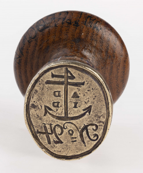 Tłok obramowany gładkim otokiem, w polu kotwica, po jej obu stronach litery A - D / I - D. Pod kotwicą napis: N=24
