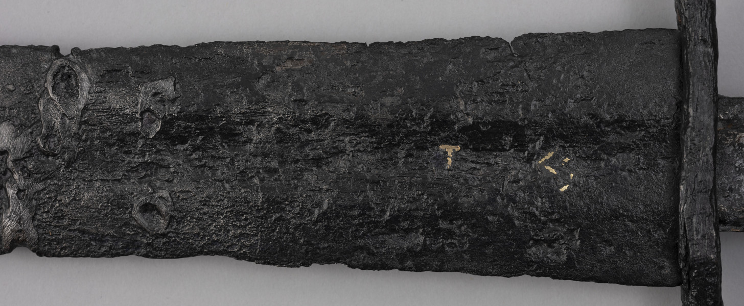 miecz typu XIVa J2 (Oakeschott) - detal; Miecz długi półtoraręczny. . Powierzchnia z wżerami pokorozyjnymi. Typ wg Oakeschotta: XIVa J2 (ewentualnie XIIIa).