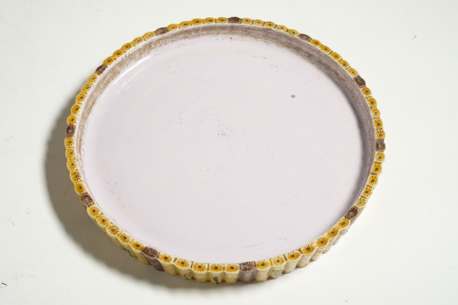 duże naczynie cylindryczne, o grubych ściankach, z podstawką. Zewnętrzna powierzchnia ścianek modelowana jest na kształt wiązek łodyg bambusowych przewiązanych wstążką z kokardą. Łodygi malowane są naturalistycznie, w kolorze żółtym i brązowym. Donica i podstawka pokryte są wewnątrz polewą w kolorze liliowym. 