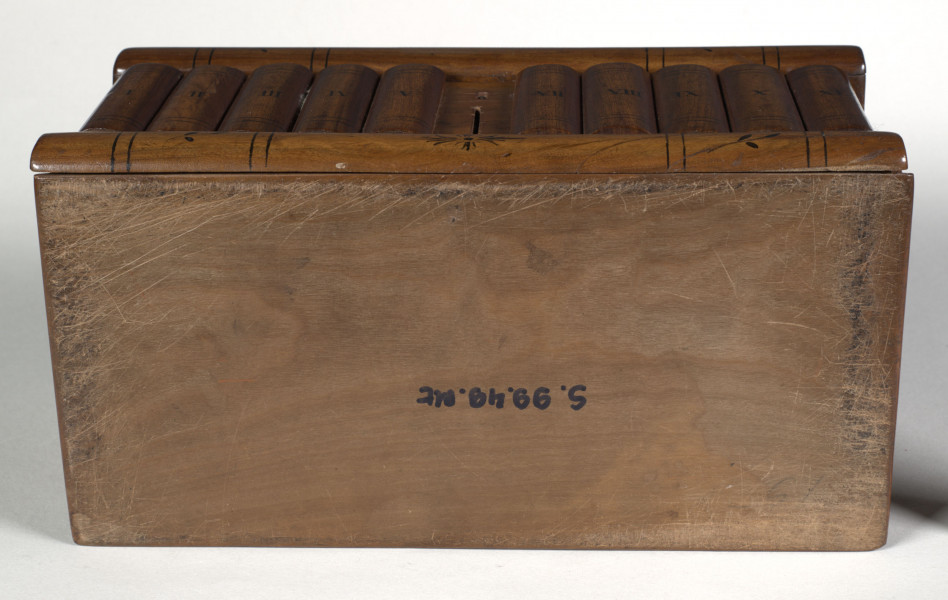 Kasetka drewniana – prostopadłościenna; elementy konstrukcyjne fornirowane oraz intarsjowane, z malowanym czernią detalem i konturowaniem.