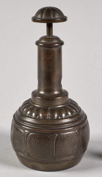 Przyrząd do przycinania końcówek cygar. Posiada gruszkowaty kształt, a wykonany jest z blachy mosiężnej, z segmentów łączonych lutowaniem