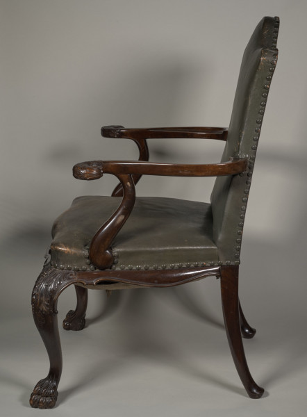 Fotel wsparty na czterech wygiętych nogach zakończonych u dołu formą łapy zwierzęcej, u nasady rzeźbionych w motywy roślinne