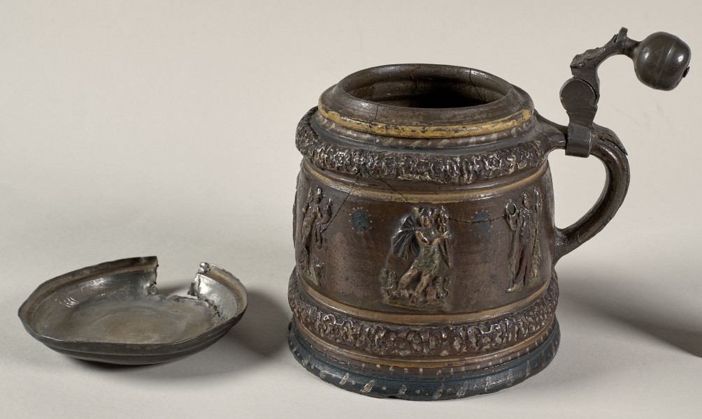 Kufel cylindryczny, lekko zwężający się ku górze, z wyodrębnionym na brzuścu pasem z pojedynczymi, siedmioma postaciami mitologicznymi, m.in. Hermesem, Jazonem, Posejdonem. 