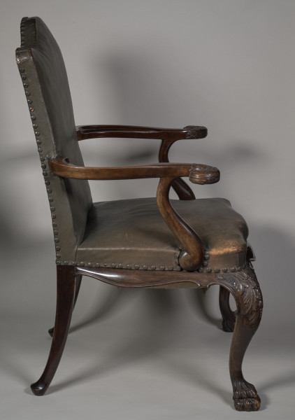 Fotel wsparty na czterech wygiętych nogach zakończonych u dołu formą łapy zwierzęcej, u nasady rzeźbionych w motywy roślinne