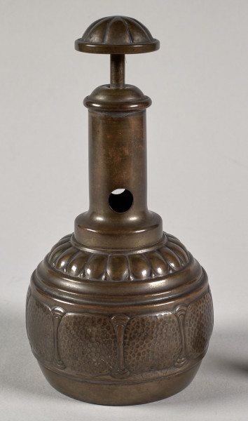 Przyrząd do przycinania końcówek cygar. Posiada gruszkowaty kształt, a wykonany jest z blachy mosiężnej, z segmentów łączonych lutowaniem