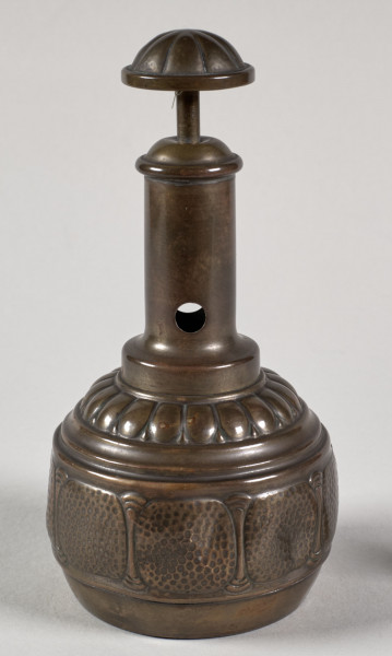 Przyrząd do przycinania końcówek cygar. Posiada gruszkowaty kształt, a wykonany jest z blachy mosiężnej, z segmentów łączonych lutowaniem