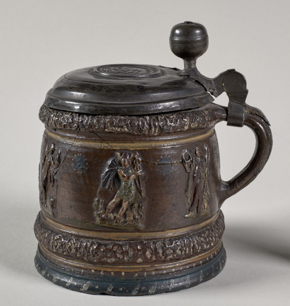 Kufel cylindryczny, lekko zwężający się ku górze, z wyodrębnionym na brzuścu pasem z pojedynczymi, siedmioma postaciami mitologicznymi, m.in. Hermesem, Jazonem, Posejdonem. 