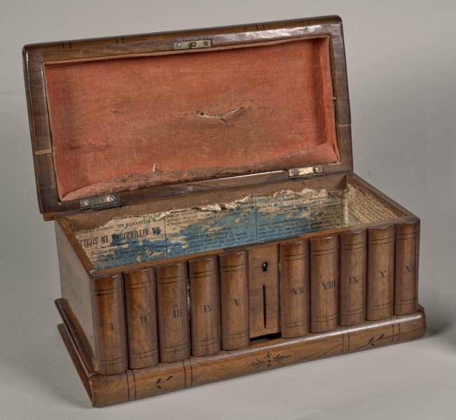 Kasetka drewniana – prostopadłościenna; elementy konstrukcyjne fornirowane oraz intarsjowane, z malowanym czernią detalem i konturowaniem.