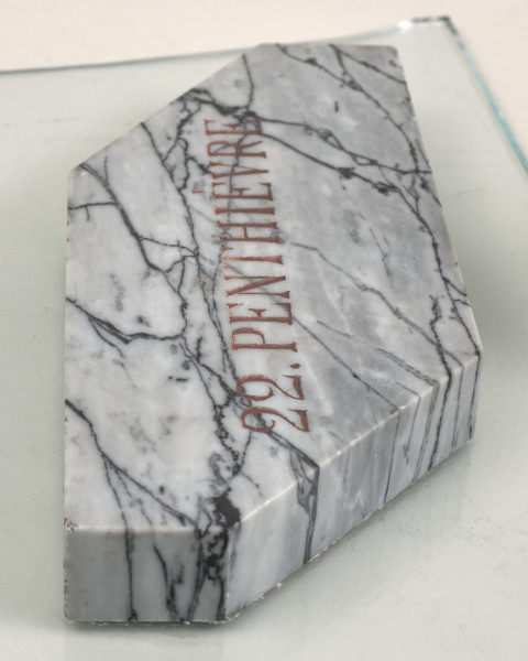 Kamień pamiątkowy z białego marmuru, ma napis: 