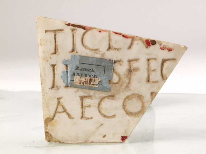 Kamień pamiątkowy z białego marmuru, ma napis: 