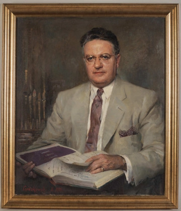 S.13498MŁ Portret siedzącego mężczyzny w okularach. Mężczyzna ubrany w jasny garnitur, białą koszulę i bordowy krawat. W rękach trzyma książkę z zapisem nutowym. Za prawym ramieniem fragment organów. Obraz sygnowany w prawym dolnym rogu.