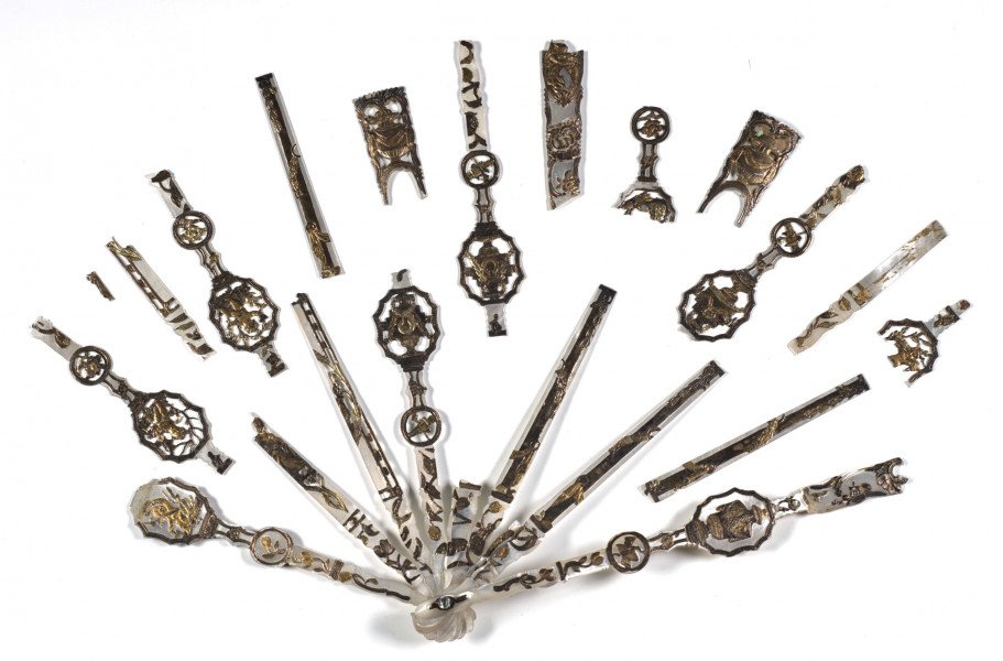 wachlarz konstruowany z profilowanych żeberek wyciętych z macicy perłowej, ułożonych promieniście, spinających rączkę z obręczą zewnętrzną. 