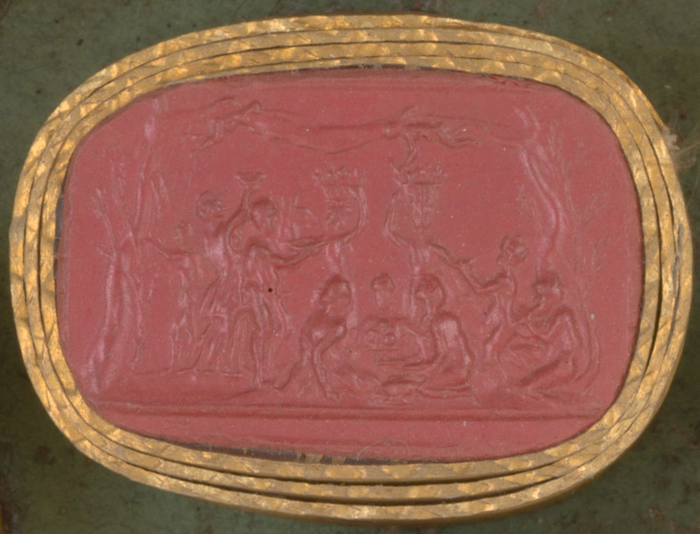 czerwona owalna gemma w grubym złotym obramowaniu, widoczna grupa ucztujących postaci pomiędzy dwoma drzewami, nad nimi putta rozciągają velum. Dwie postaci trzymają kosze z owocami, jedna gra na instrumencie dętym, w centrum trzy postaci siedzą na ziemi.