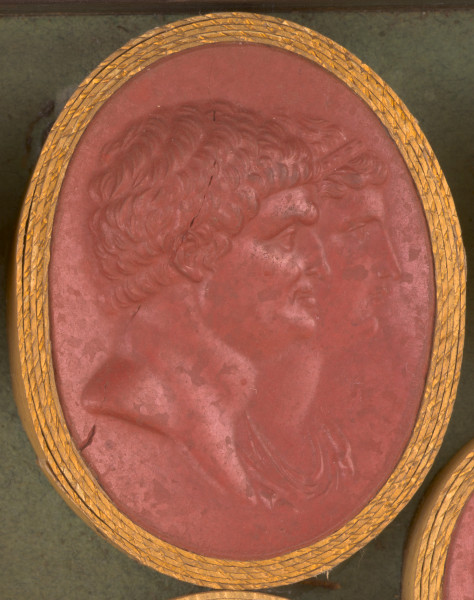 czerwona gemma, owalna pionowa, w grubym złotym obramowaniu. Podwójny portret mężczyzny i kobiety, ukazanych w prawym profilu. Mężczyzna o krótkich kręconych włosach, lekko garbatym nosie, mocno zarysowanej szczęce i grubym karku. Kobieta o prostym nosie i delikatnie rozchylonych ustach.