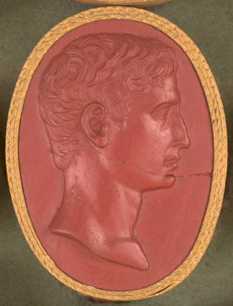 czerwona duża gemma, owalna pionowa, w złotym otoku. Prawy profil młodego mężczyzny o krótkich, falujących włosach. Nos u nasady dość wydatny, niżej nieco zagięty, wyraźnie zaznaczona broda.