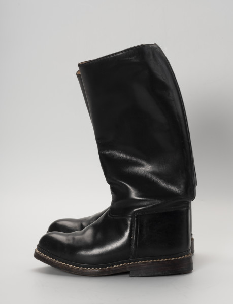 para butów oficerek - Ujęcie prawy bok; Para męskich, skórzanych butów z wysokimi cholewami, zrobionych na wzór oficerek przedwojennych. Przyszwy i cholewy wykonane z barwionej na czarno skóry, przyszyte dratwą do podeszwy podwójnymi szwami.