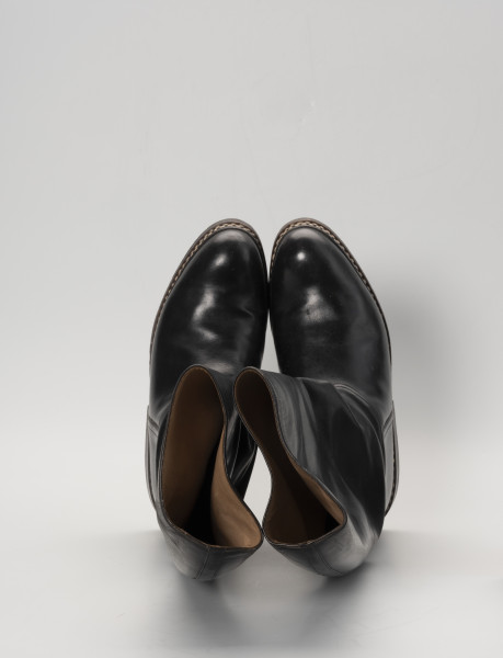 para butów oficerek - Ujęcie z góry; Para męskich, skórzanych butów z wysokimi cholewami, zrobionych na wzór oficerek przedwojennych. Przyszwy i cholewy wykonane z barwionej na czarno skóry, przyszyte dratwą do podeszwy podwójnymi szwami.
