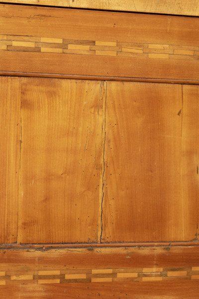 Biurko przyścienne na sześciu nóżkach graniastych zbieżnych. W części dolnej prostokątny prześwit zamknięty tylną ścianą. Po jego bokach po dwie szuflady, powyżej jeszcze trzy. Część górna ćwierćcylindryczna zamykana żaluzją chowaną pod górna płytą powyżej pięciu szufladek, boki zdobione plastycznym ornamentem cekinowym. Lico pokryte fornirem z intarsją ramkową i wzorem arkadkowym. Blat wyłożony skórą cielęcą. Uchwyty szuflad zewnętrznych i żaluzji to nałożone okucia okrągłe z tarczą, szufladki w części górnej mają uchwyty okrągłe z gładką główką.  