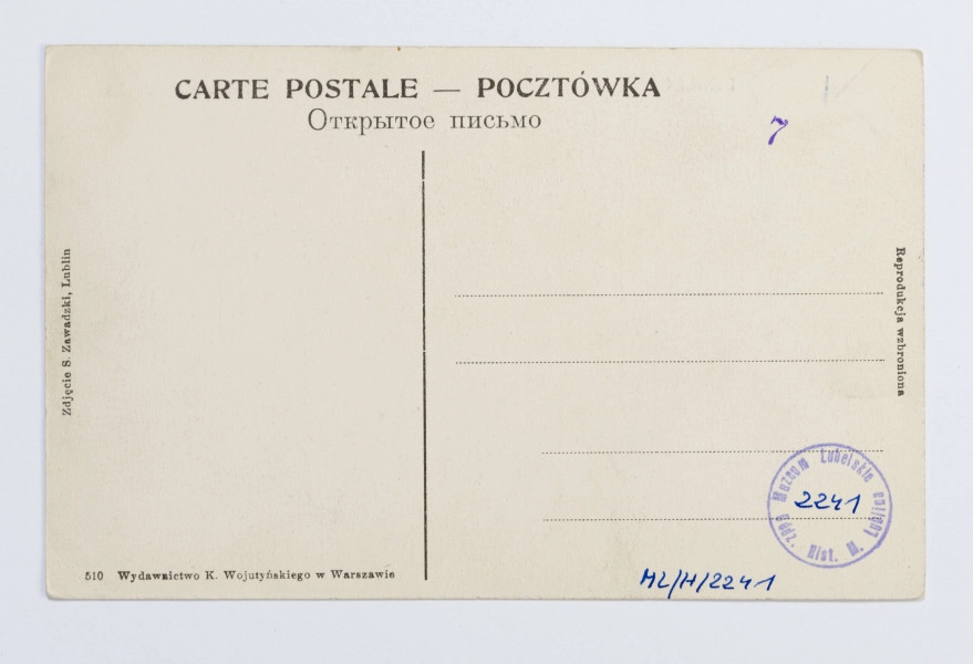 W centralnej części kartki Brama Krakowska, otynkowana, z żelazną galerią dookoła górnej kondygnacji. Po obu jej stronach przylgające dwupiętrowe kamienice, częściowo zasłonięte przez korony drzew. Na brukowanej ulicy wielu przechodniów, na pierwszym planie z prawej strony kilku mężczyzn wpatrzonych w obiektyw. Fotografia wykonana w pogodny, słoneczny dzień, pierwszy plan częściowo zacieniony. Na odwrociu informacja o autorze fotografii i wydawcy.