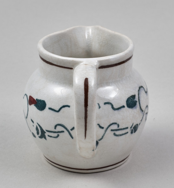 Dzbanuszek - mały, fajansowy z pękatym brzuścem i krótką szyjką o szerokiej gardzieli, którą w jednym miejscu wydłuża trójkątny wylew