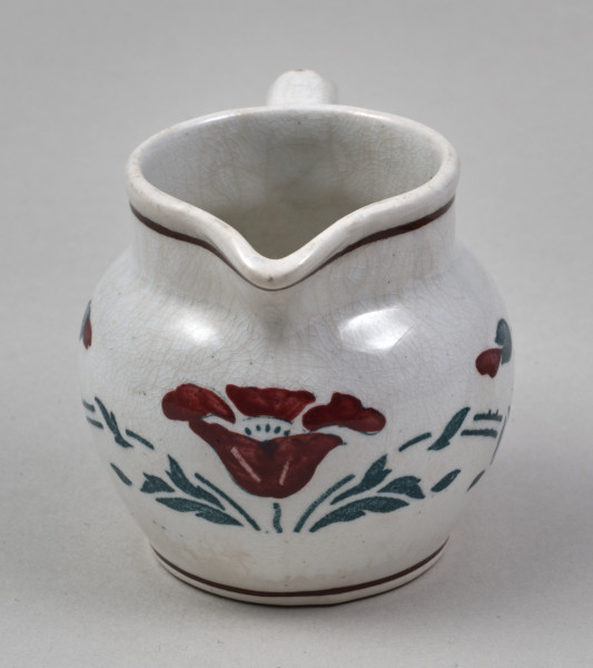 Dzbanuszek - mały, fajansowy z pękatym brzuścem i krótką szyjką o szerokiej gardzieli, którą w jednym miejscu wydłuża trójkątny wylew