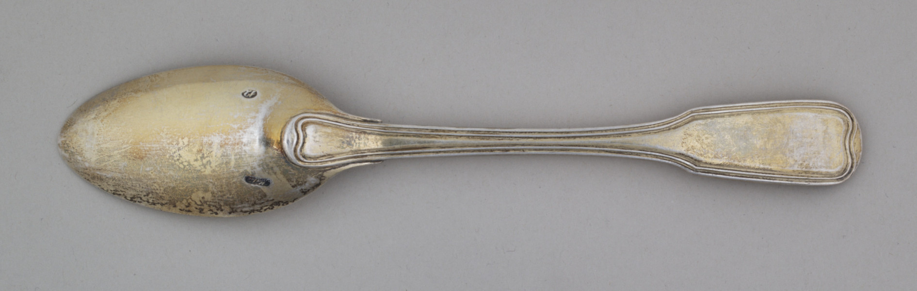 łyżka obiadowa o głębokiej owoidalnej czarce. Trzonek płaski, lekko wygięty, rozszerzający się przy zakończeniu