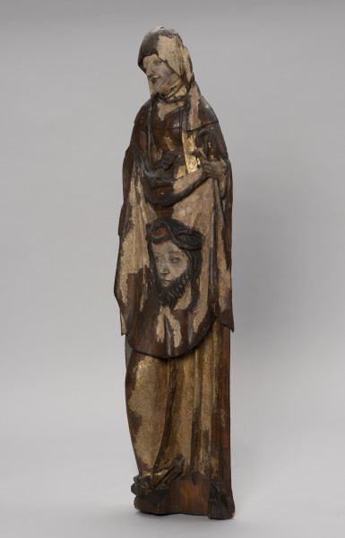 figura ołtarzowa; Święta Weronika - Ujęcie ze skosu z prawej; Smukła kobieca figura stojąca frontalnie o wydłużonej sylwetce i drobnej twarzy, polichromowana i złocona. Święta, ubrana w suknię z wysokim stanem, przewiązaną luźno opuszczonym pasem z klamrą oraz w długi płaszcz, trzyma przed sobą chustę z reliefowym wizerunkiem głowy Chrystusa w koronie cierniowej. Niewielką głowę figury otula chusta spływającą na ramiona i marszczona pod szyją podwiką. Twarz, o oczach zapatrzonych w dal i lekko pochylona w lewą stronę, wyraża smutek. Tył płaski, typowy dla rzeźb przyściennych. Brak prawej dłoni. Wyłamania drewna przy podstawie. Znaczne ubytki polichromii i złoceń.