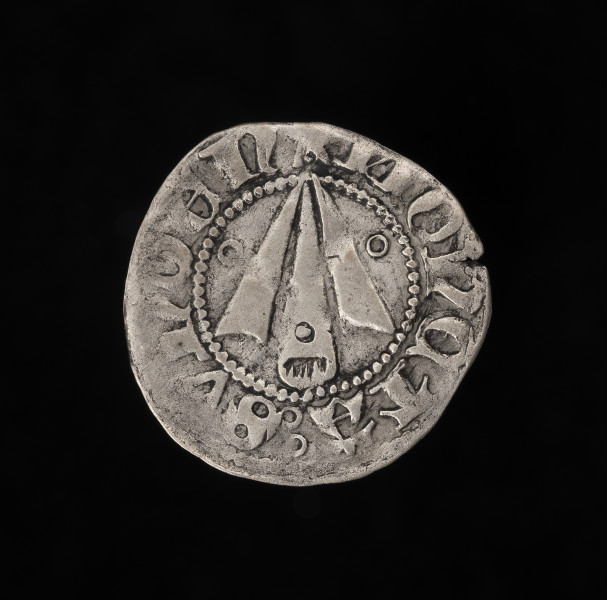 szeląg (gruby fenig) - awers; srebrna moneta; 
Na awersie grot strzały, po bokach i na środkowej części pierścienie. W perełkowym otoku napis: MONETA SVNDEN (moneta sundzka).