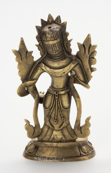 figurka Bodhisattwa Awalokiteśwara Padmapani wraz z wypełnieniem - ujęcie z tyłu; Mała, wykonana z brązu figurka. Postać ludzka o gładko zaczesanych włosach opadających do wysokości karku, schowanych za diademem. Stoi na lotosowym postumencie, gładka powierzchnia z grawerowanym ornamentem w postaci zakręcających i ukośnych linii. Ubrana jest w szaty królewskie: przewiązaną w talii tkaninę z paskiem od którego odchodzą łańcuszki z paciorków. Na szyi naszyjnik z paciorków. Do ramion przylegaja atrybuty Prawa ręka uniesiona jest na wysokości klatki piersiowej, lewa opada wzdłuż ciała, zatrzymując się na wysokości biodra. Z ramion figurki zwisa przewieszona skóra antylopy.