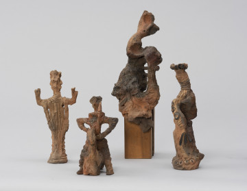 zespół rzeźb; Zmierzch królów - ujęcie z przodu; Zespół surrealistycznych antropomorficznych i zoomorficznych figur o ceglasto-szarej barwie, od lewej:
a) Postać męska o zwartych nogach, uniesionych w górę, zgiętych w łokciach ramionach. Sterczące nakrycie głowy, spodnie bufiaste na biodrach, na nogach poprzecznie nałożone paski gliny. Na torsie i szyi ryty.
b) Jeździec na koniu bez nóg. Szeroko rozstawione ręce, wsparte dłońmi o biodra, w lewej sterczący w górę miecz. Głowa mała na długiej szyi, na szyi kryza. Na torsie rytem zaznaczone łuski pancerza. W stosunku do postaci koń mały, schematycznie potraktowany.
c) Ogólnie potraktowanej stojącej na postumencie postaci kobiecej. Głowa odchylona w prawo, w tył, tors w lewo, fragmentarycznie zaznaczony. Od bioder draperie fałd spódnicy. Po prawej, przy postaci pionowa forma połączona trzema poziomymi trzpieniami z postacią. Na wysokości torsu postaci forma nieco powiększa się i łączy z postacią.
d) Skręcona spiralnie, wysmukła postać kobieca o tektonicznej formie. Twarz pociągła, na głowie duży, płaski beret. Na grubej szyi rytmiczne krążki. Prawe ramię opuszczone ukośnie w dół, w ręce wachlarz. Na ramieniu trzy czarne krążki. Na podstawie 4 