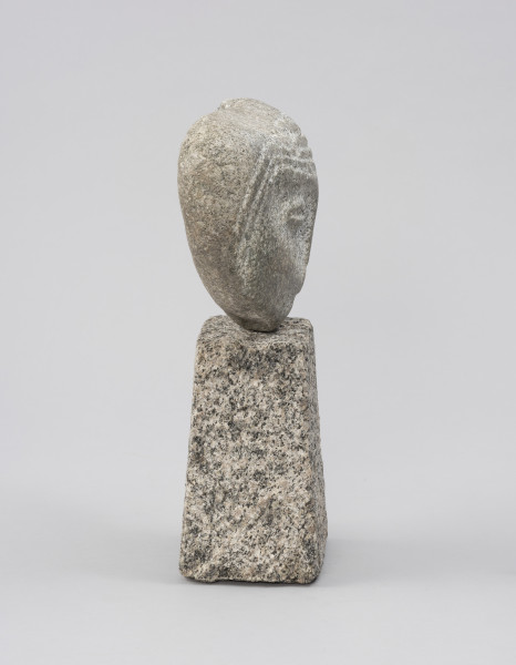 rzeźba; głowa - Ujęcie z prawej; Spłaszczona, bliska owoidalnej głowa, osadzona na kostce w kształcie ściętego ostrosłupa. Rysy twarzy: konturowo zaznaczone oczy. Ryt ornamentalny włosów widoczny tylko na froncie skały, bezpośrednio wokół twarzy.