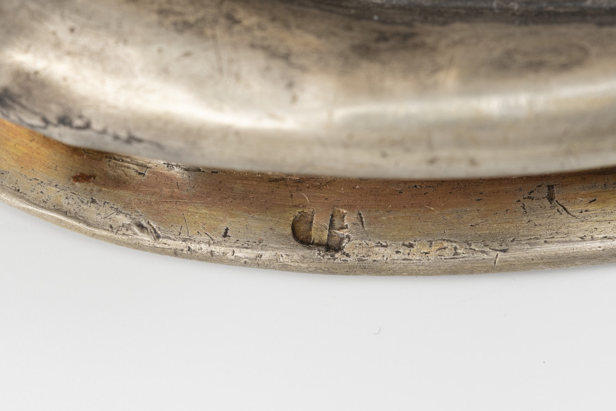 dzban na wino komunijne - detal; punca znak; 	na brzegu stopy w półokrągłej tarczy poprzeczna belka - znak miejski Stargardu