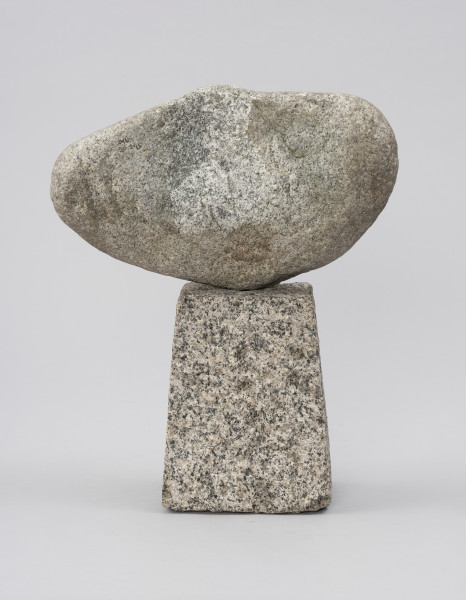 rzeźba; głowa - Ujęcie z tyłu; Szeroka, spłaszczona, bliska owoidalnej głowa dołem lekko wydłużona, osadzona na kostce w kształcie ściętego ostrosłupa. Tył głowy surowy, nieopracowany.